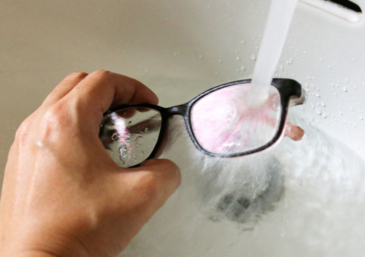 Rửa mắt kính qua nước trước khi lau