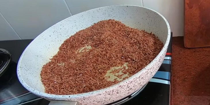 Làm nóng chảo sau đó cho gạo lứt vào rang 
