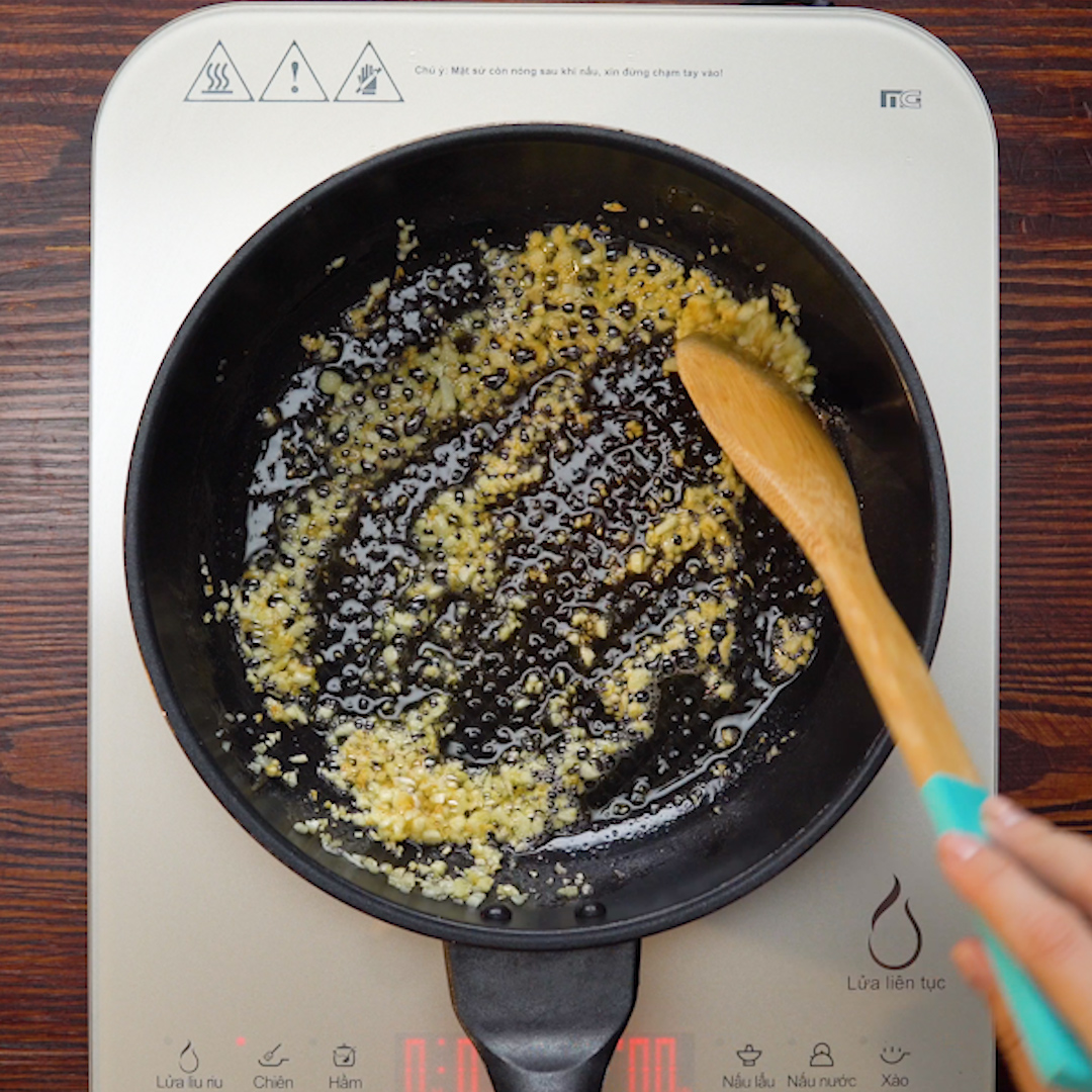 Bước 2: Bạn cho 20 gr vào chảo đun chảy ở lửa nhỏ, sau đó thêm tỏi băm nhuyễn vào phi thơm và tắt bếp.