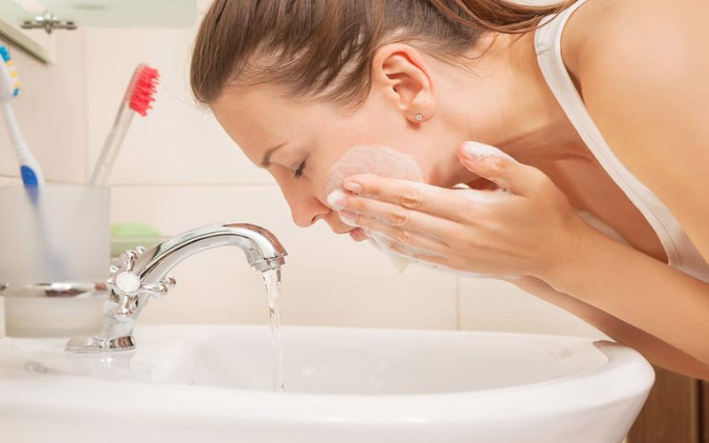 Làm sạch da mặt bằng việc tẩy trang và rửa mặt với sữa rửa mặt