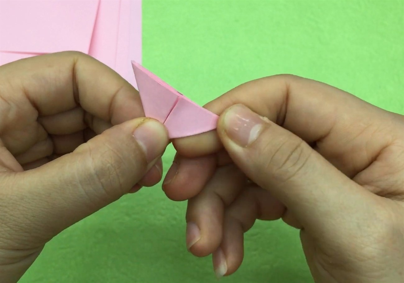 Gấp đôi mảnh giấy rồi tiếp tục gấp lại thành hình tam giác như hình