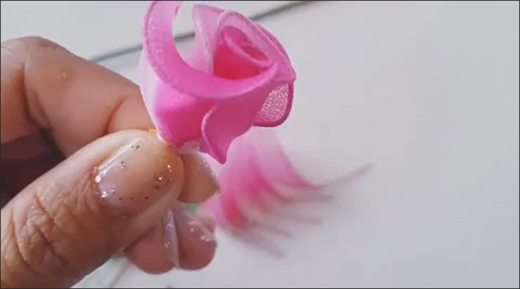 Cách làm hoa hồng bằng vải voan và vải lụa đơn giản làm quà tặng 20/10 > Bạn dùng chỉ quấn quanh để cố định các cánh hoa lại với nhau (Nguồn ảnh: Youtube HANDMADE TV)