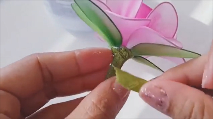 Bạn dùng keo sáp quấn quanh thân hoa (quấn keo sát gốc để che mối chỉ). (Nguồn ảnh: Youtube HANDMADE TV)