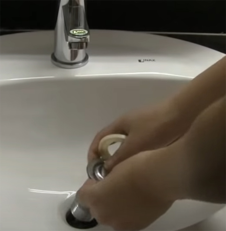 Bạn hãy sử dụng dụng cụ mở đai ốc, đưa vào lỗ hở trên bề mặt bồn rửa tay.