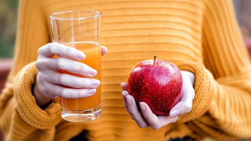 Cô gái cầm táo và ly nước ép táo