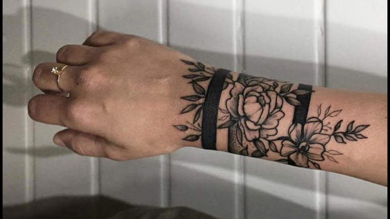 Rose bracelet tattoo on men's wrist