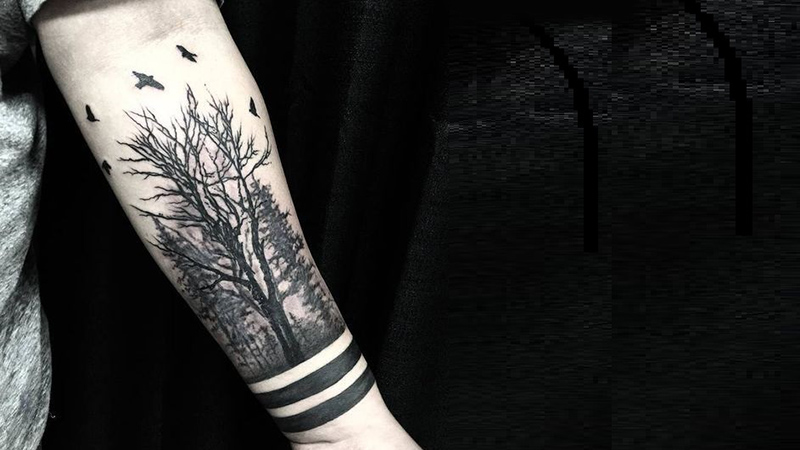Hὶnh xăm cây kết hợp với chim bay và vὸng tay màu đen ở cổ tay cho nam