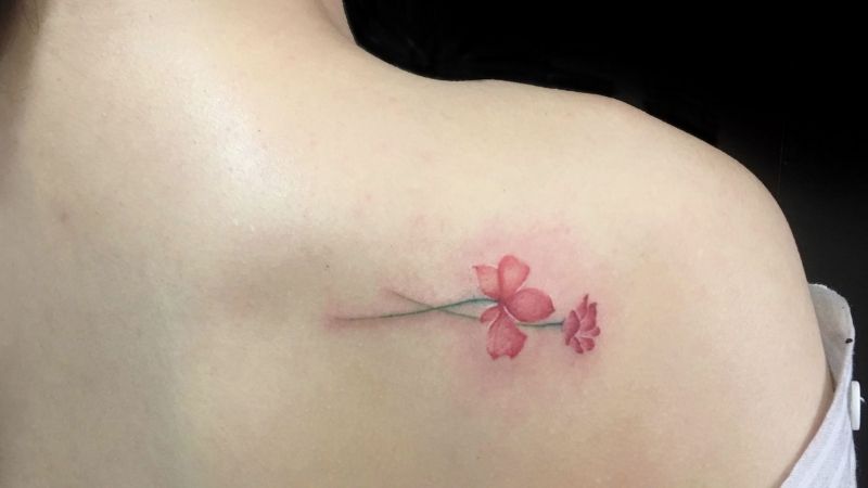 Unique female tattoo with red flower petals