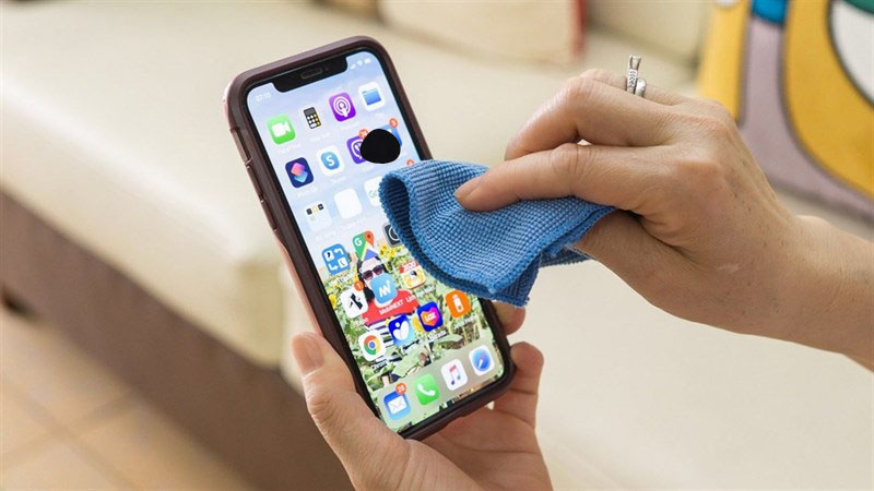 đặt ngón tay vừa quấn vải xuống vị trí bị chảy mực trên điện thoại 