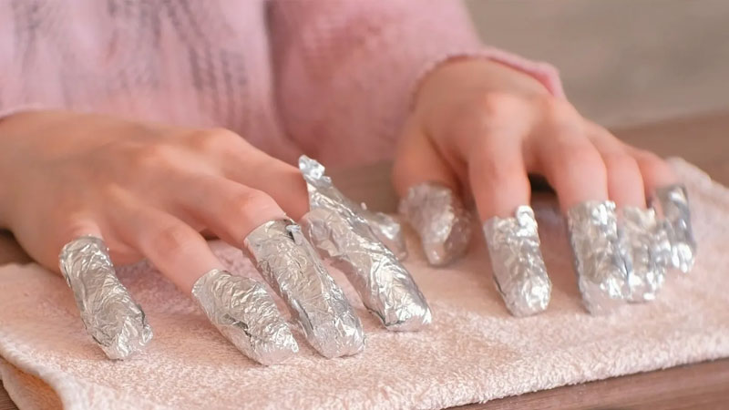 Soak a cotton ball with acetone solution and place it on the nails, wrap it with foil