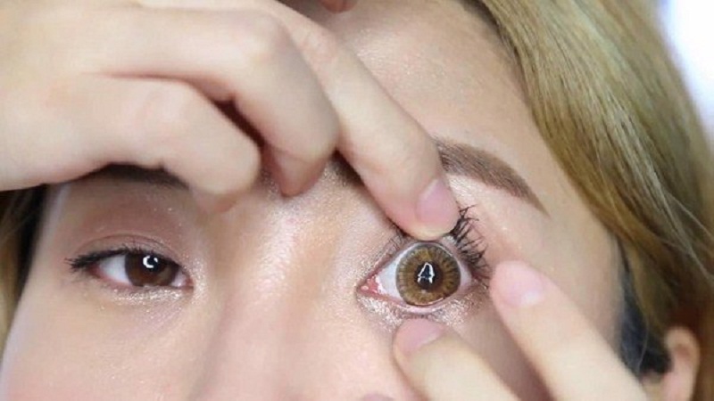 Nên đeo lens trước khi trang điểm để tránh bụi phấn rơi vào mắt gây cộm mắt