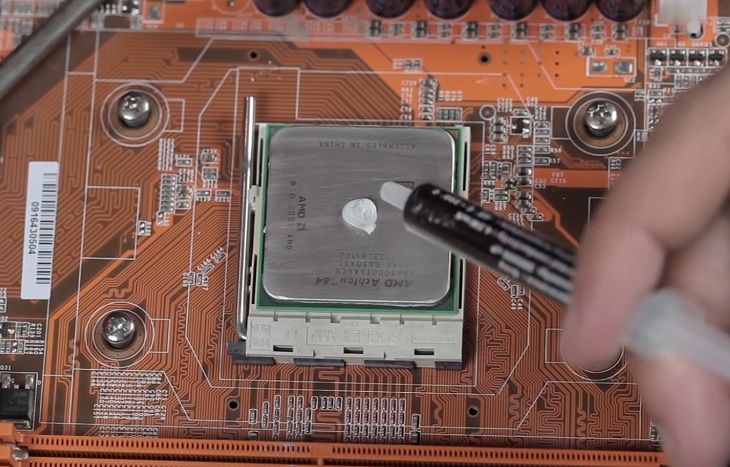 Cho lượng nhỏ keo tản nhiệt cỡ bằng 1 hạt đậu vào giữa CPU (trung tâm con chip).