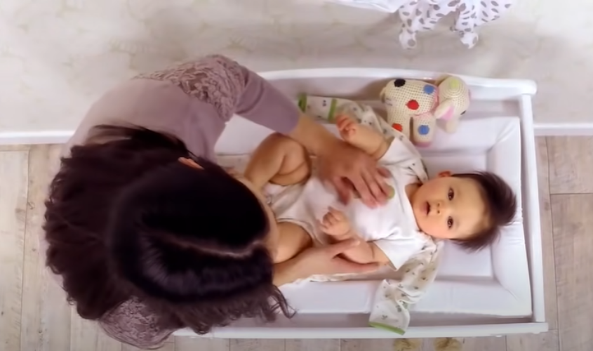 Đặt bé lên sao cho cổ bé khớp với cổ áo