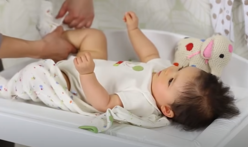 Luồn chân bé vào ống quần.