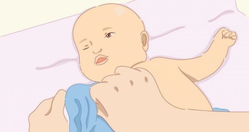 Dồn tay áo xuống cổ tay và nhẹ nhàng đưa tay bé qua