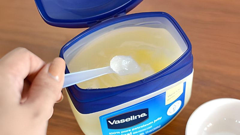 Cho vào bát 2 - 3 giọt dầu em bé và 1 thìa sáp dưỡng ẩm vaseline