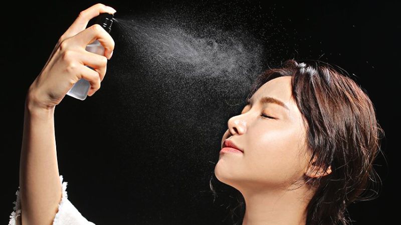 Spray makeup spray on face
