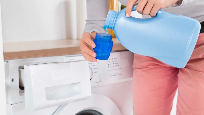 Pouring detergent and fabric softener directly onto clothes