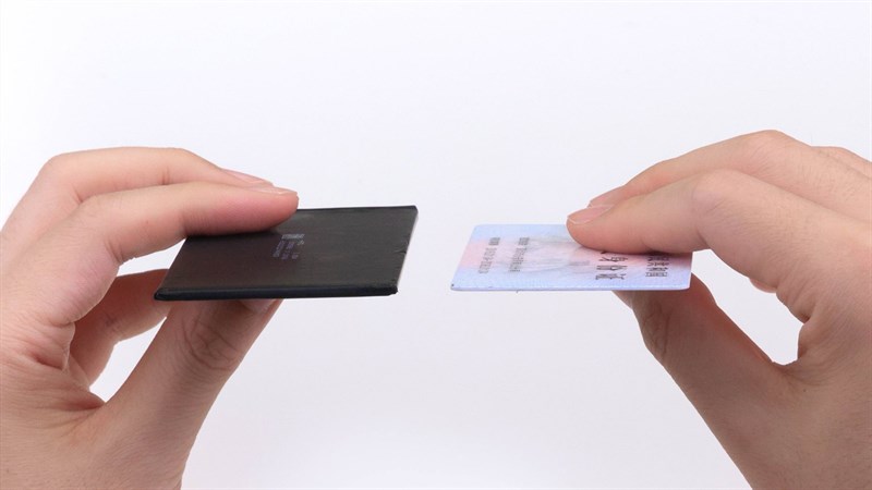 So sánh độ mỏng của viên pin bên trong Honor Magic V2 và một tấm thẻ