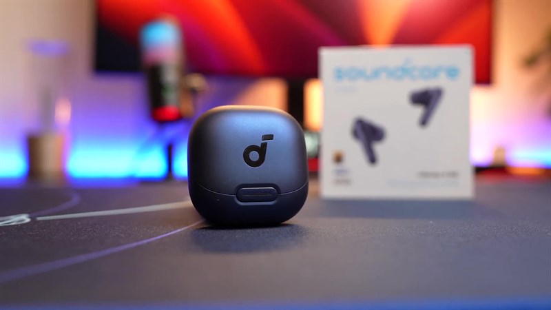 Mặt trước của hộp sạc có một nút bấm lớn và logo Soundcore nổi bật ở trung tâm.