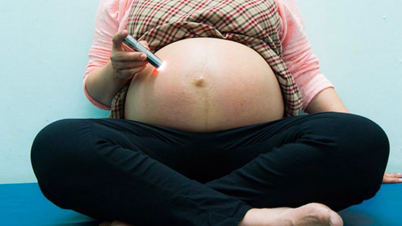 Soi đèn pin vào phần bụng của mẹ