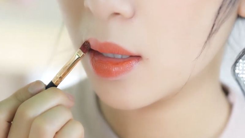 Use a brush to apply lipstick