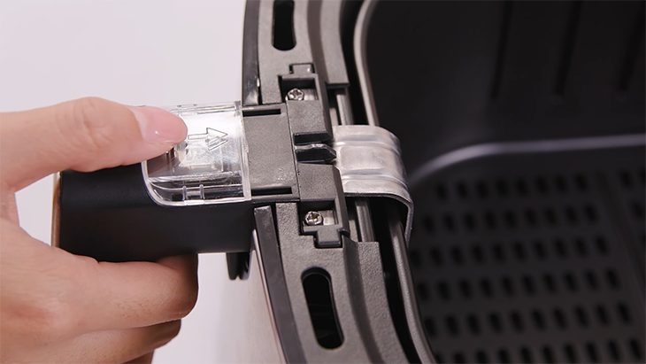 Bạn chỉ cần đẩy nhẹ nắp nhựa lên trên và bấm vào nút lẫy là rổ chiên sẽ rời ra khỏi lòng