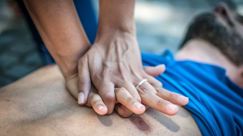 Đan 2 bàn tay vào nhau sau đó đặt bàn tay này lên mu bàn tay kia đang đặt trên xương ức