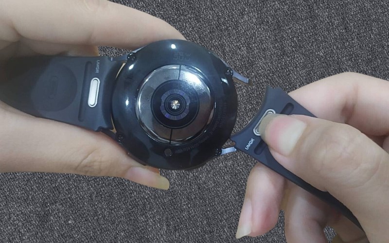 Bấm v&agrave; giữ n&uacute;t kim loại tr&ecirc;n d&acirc;y đồng hồ để thay d&acirc;y đồng hồ