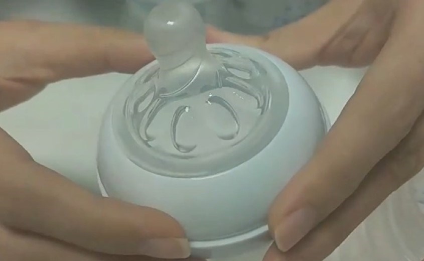 Nhấn nhẹ núm vú cho khít với nắp vặn