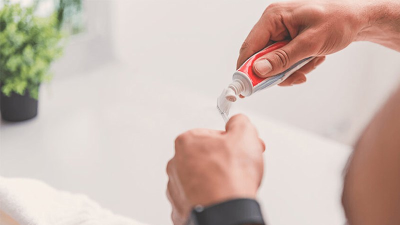 Lấy b&agrave;n chải k&egrave;m ch&uacute;t kem đ&aacute;nh răng ch&agrave; nhẹ l&ecirc;n mặt k&iacute;nh