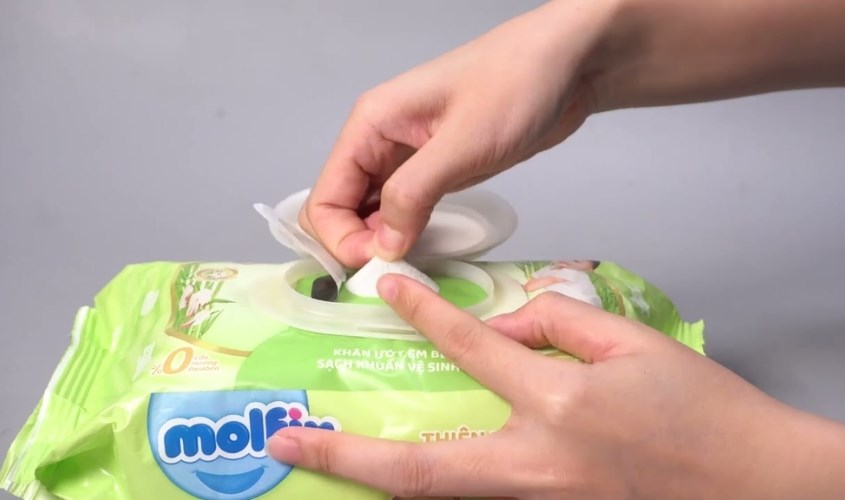 Mở nắp bịch khăn giấy ướt Molfix và rút lượng giấy cần dùng