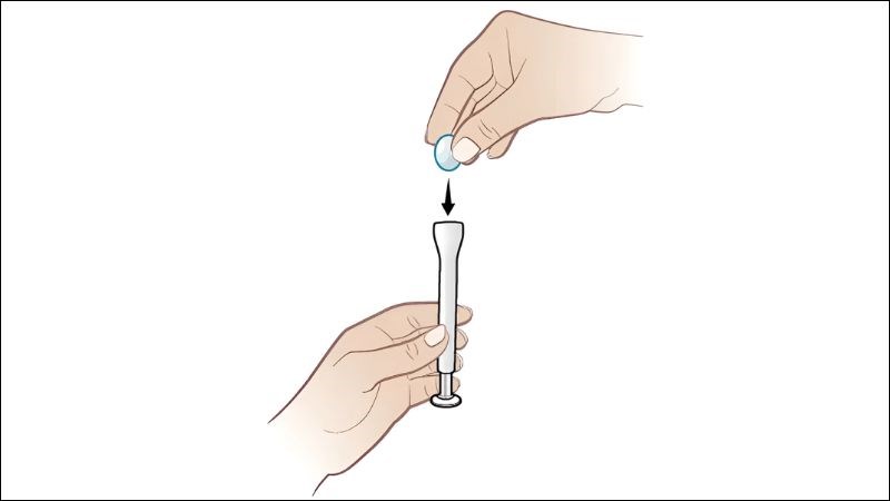 Đưa vi&ecirc;n thuốc v&agrave;o phần cuối dụng cụ đặt thuốc