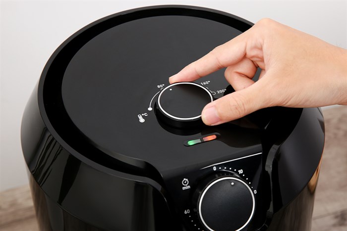 Một núm vặn nhiệt độ dao động từ 80 đến 200°C, trong khi một núm điều chỉnh thời gian từ 0 đến 60 phút.