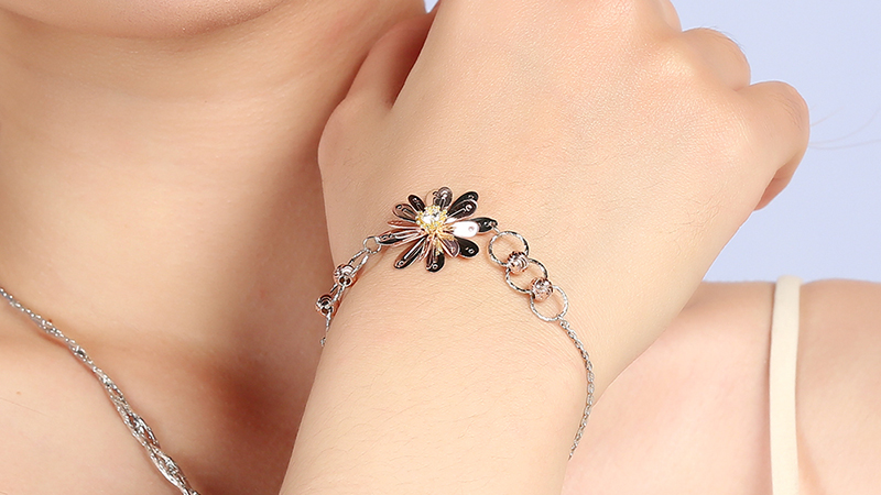 Lắc tay dạng dây xích bản nhỏ, kết hợp với mặt hoa nhiều cánh nổi bật 